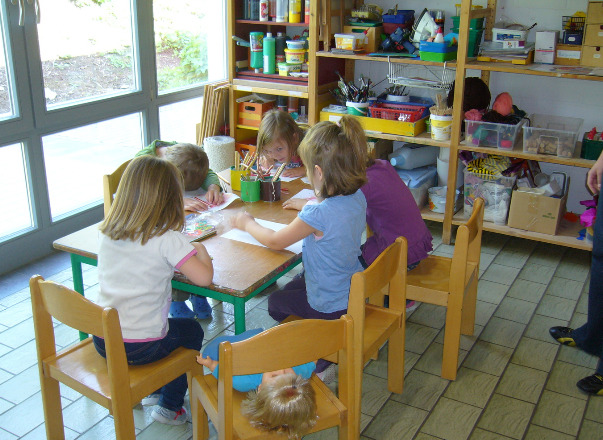 Kindergarten - Kinder sitzen an einem Tisch und malen
